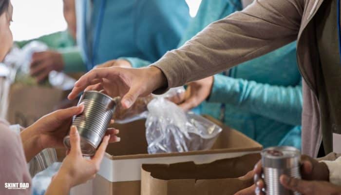Volunteers sort food bank donations, placing tins and packets into boxes at a community centre, ready to help families in need this winter.