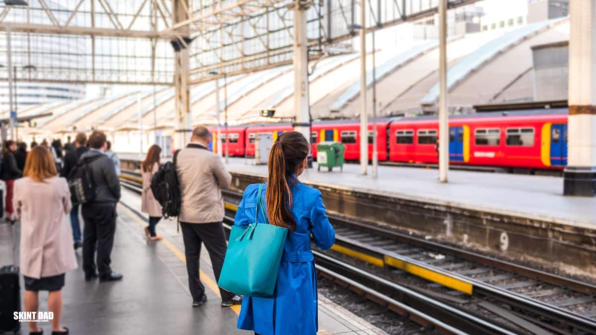 A lady waiting for a train and thinking about the real cost of going to work.