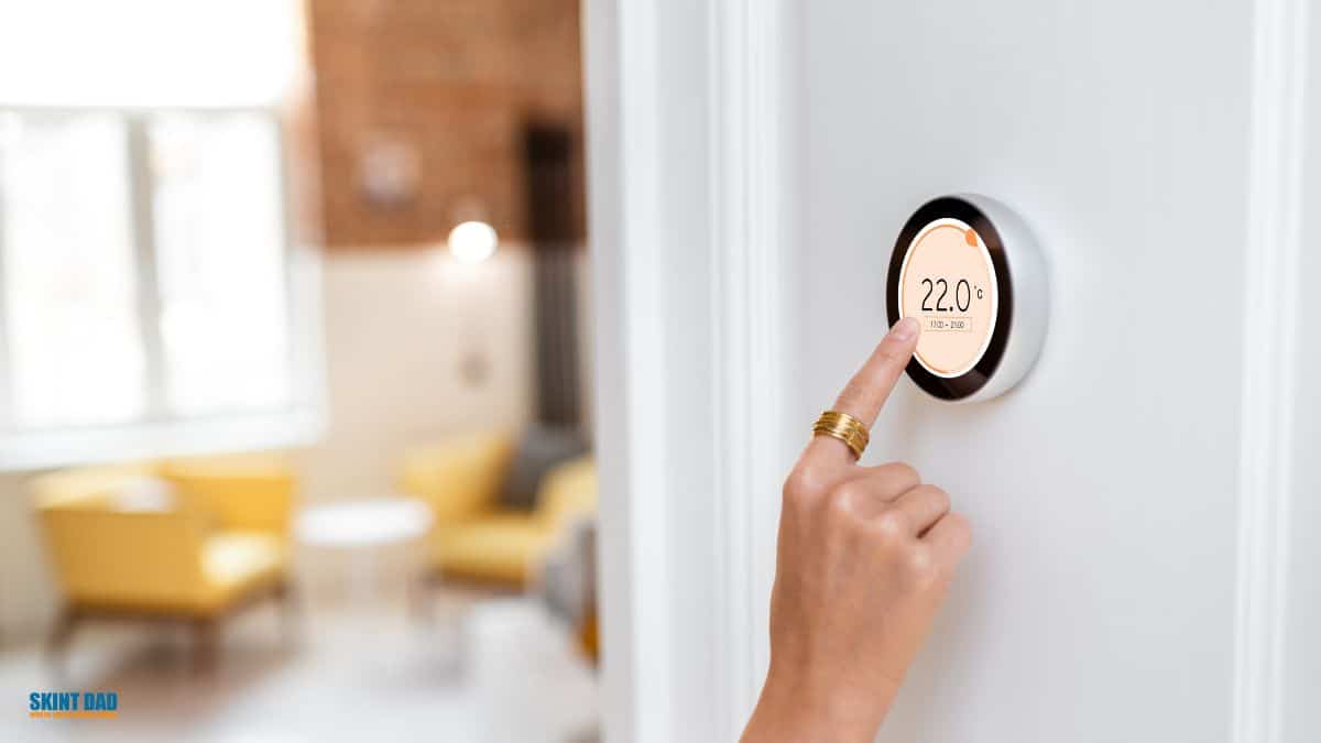 Hand turning a smart thermostat up by one click to reflect the small January Ofgem price cap increase.