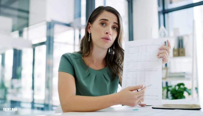 Person looking at a payslip at a kitchen table after the National Living Wage rise.