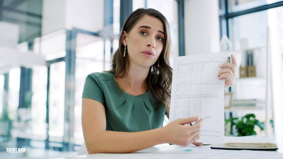 Person looking at a payslip at a kitchen table after the National Living Wage rise.