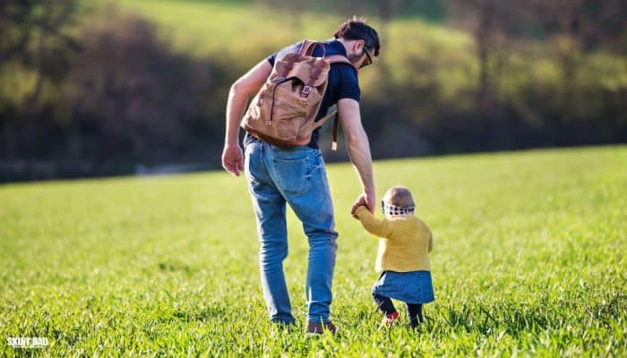 Parent and child holding hands while walking, representing everyday families supported by the 2026 Child Benefit rise.