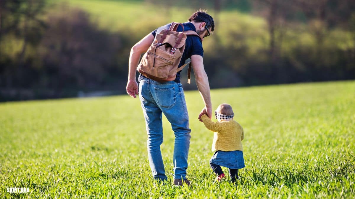 Parent and child holding hands while walking, representing everyday families supported by the 2026 Child Benefit rise.