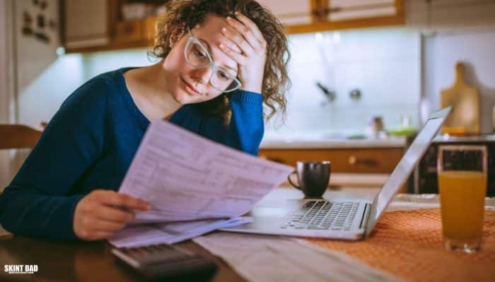 Bills, bank card and mobile phone on a kitchen table showing everyday money pressures for UK families