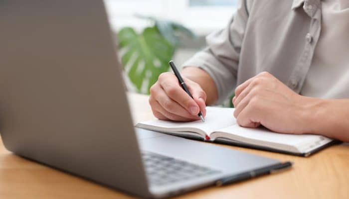 Person testing a website on a laptop at home, following simple tasks and giving feedback as part of a paid website testing side hustle.