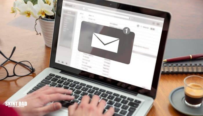 Person checking a job offer email on a laptop at home