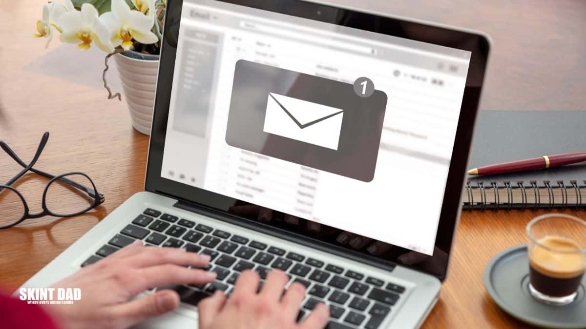 Person checking a job offer email on a laptop at home