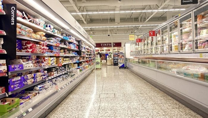 Yoghurts and frozen food lining an aisle in an Asda supermarket