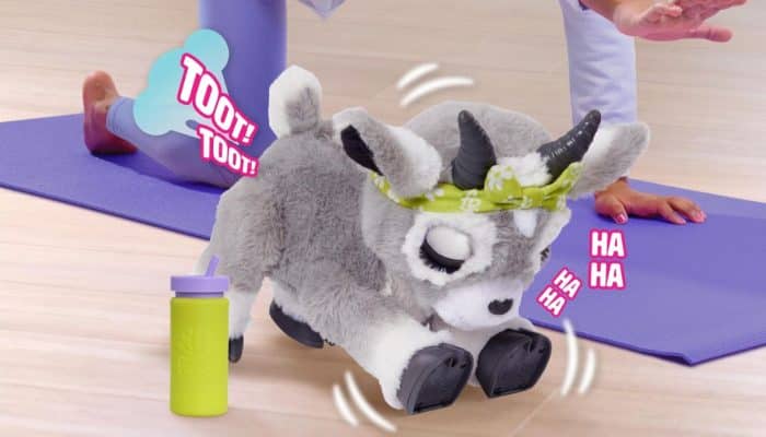 Child playing with FurReal Daisy the Yoga Goat toy on a purple mat