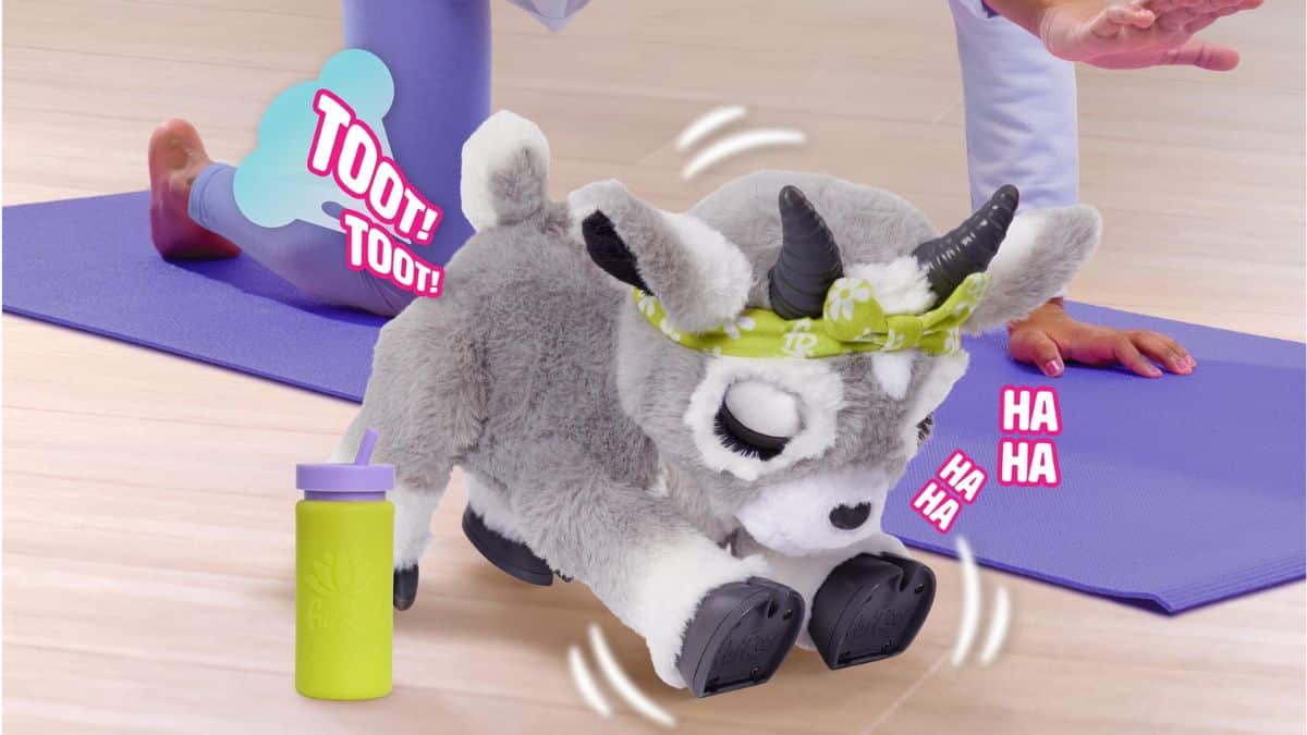 Child playing with FurReal Daisy the Yoga Goat toy on a purple mat