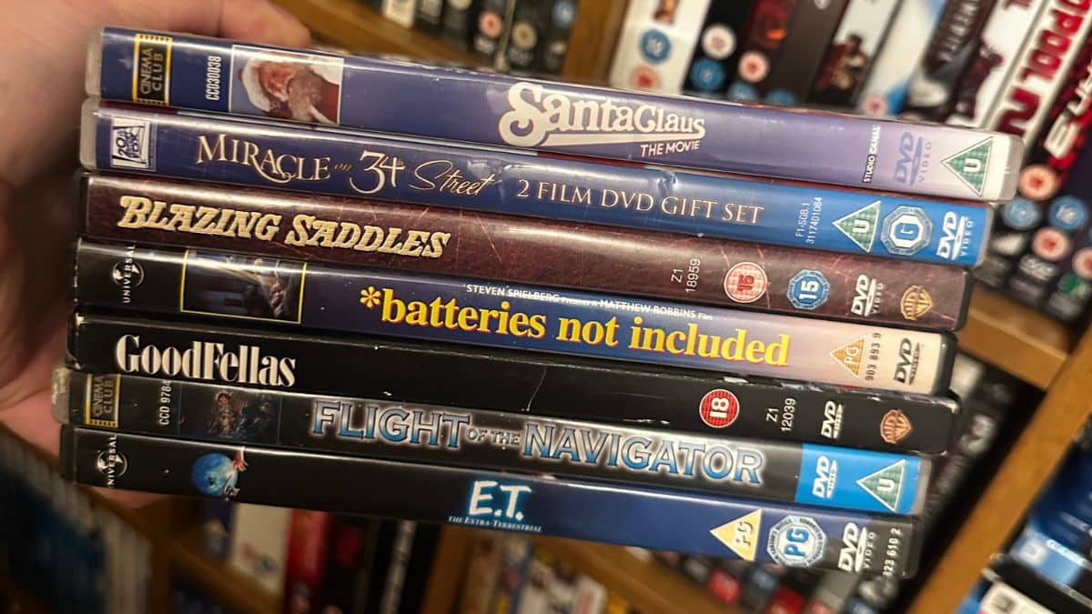 Stack of second-hand DVDs being sorted for resale