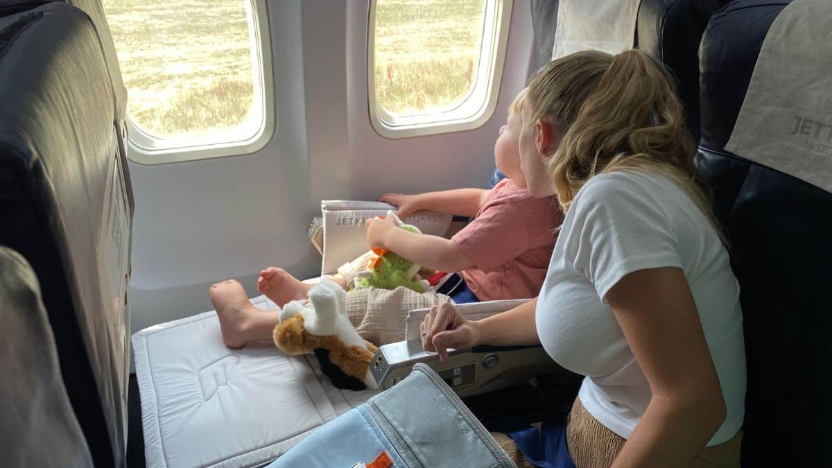 Mother and young boy sitting together on an aeroplane