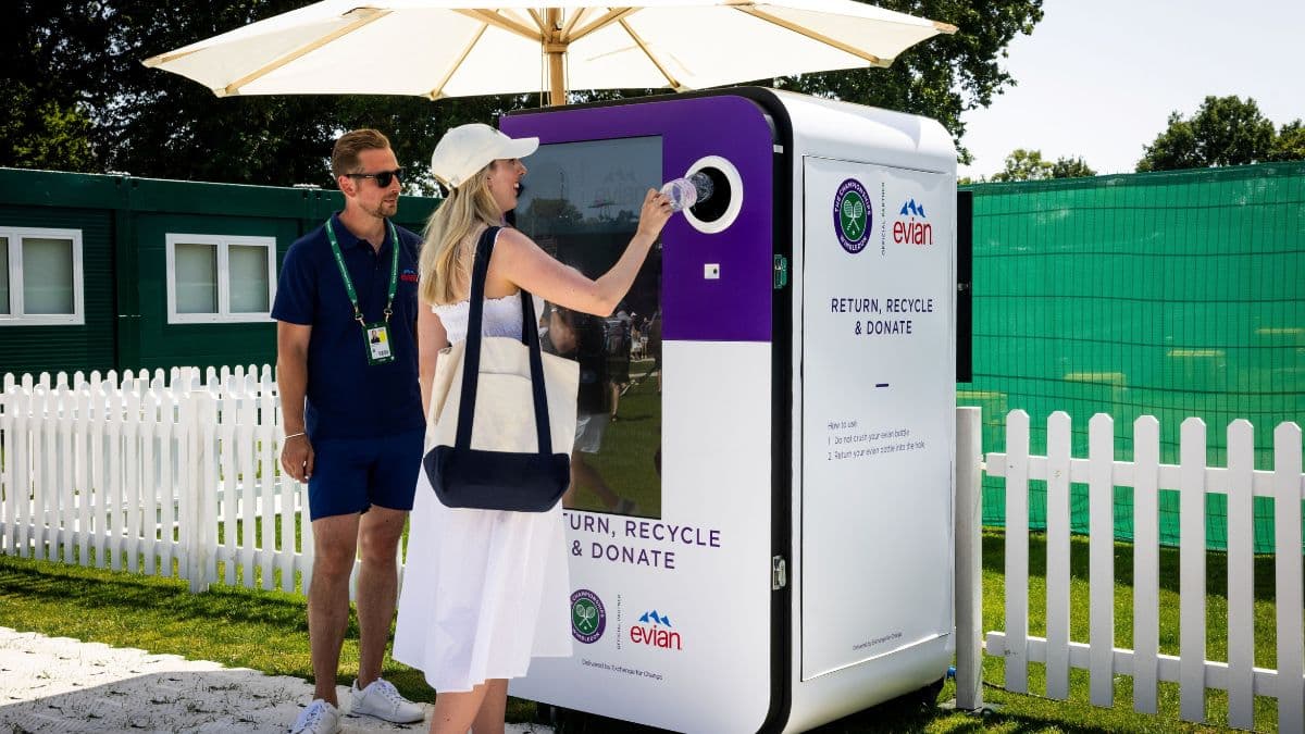 Woman returning an Evian plastic bottle into a reverse vending machine at a Wimbledon Deposit Return Scheme trial