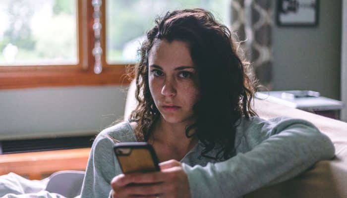 Woman looking at a smartphone while sitting at home