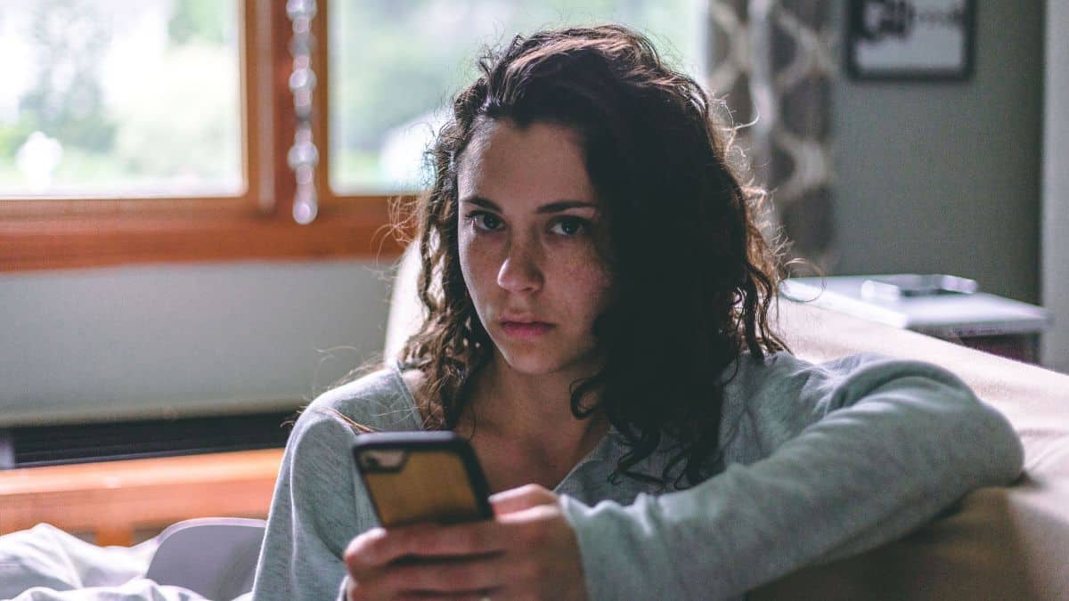 Woman looking at a smartphone while sitting at home