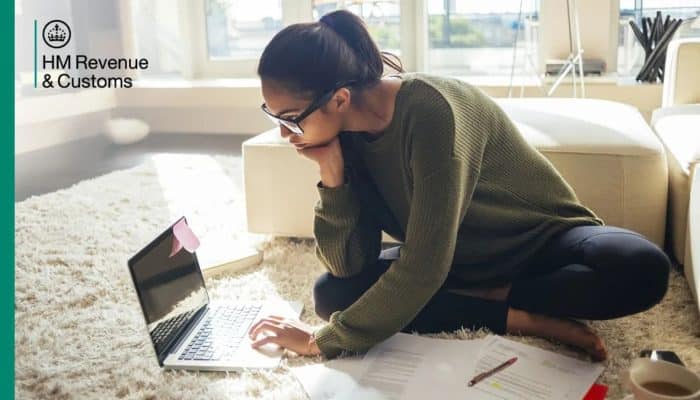 Person using a laptop with HMRC branding for online tax services