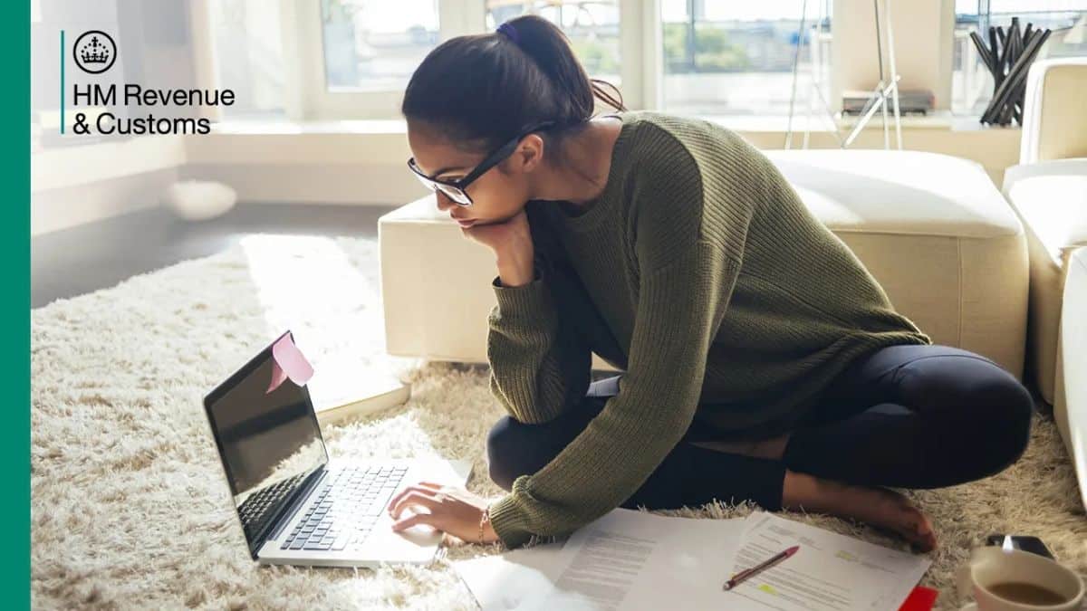 Person using a laptop with HMRC branding for online tax services