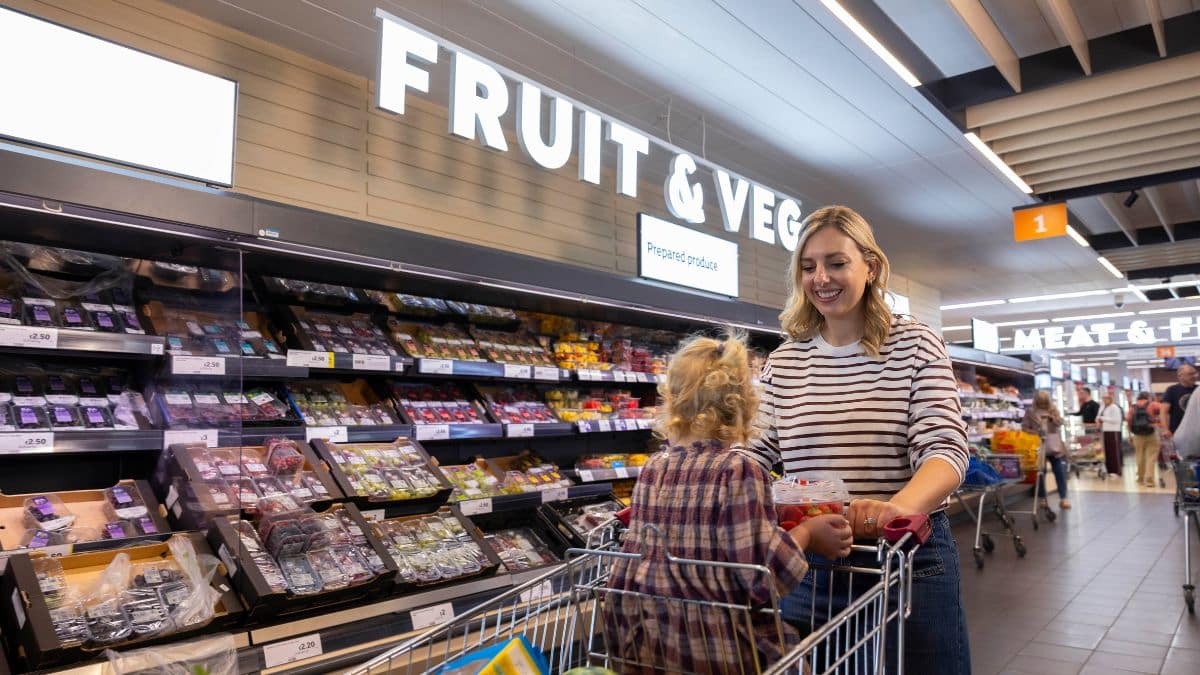 Woman and child shopping in the fruit and vegetable aisle at Sainsbury's