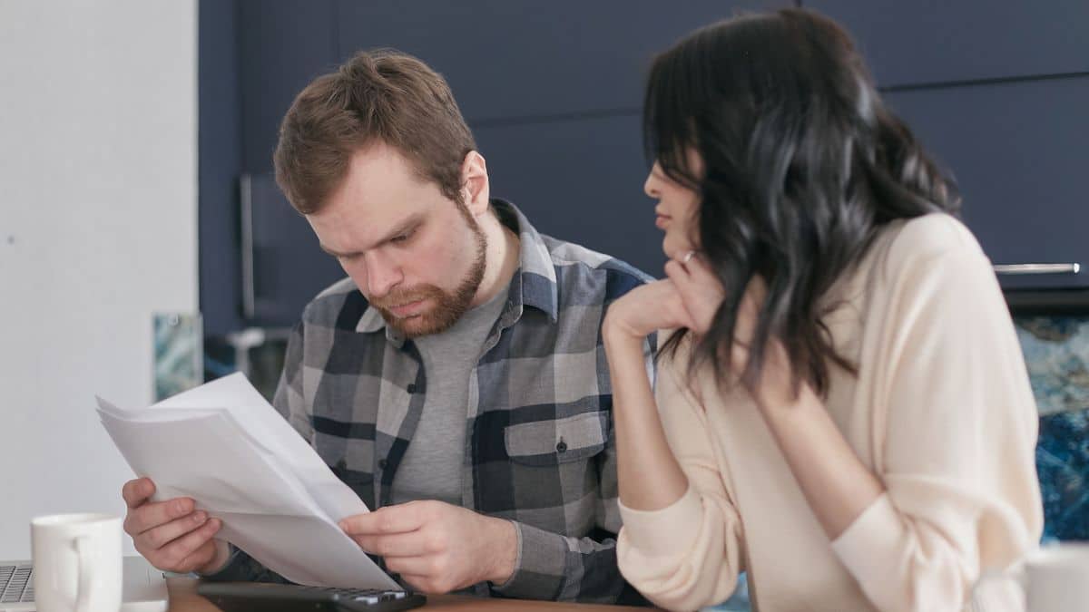 Couple reviewing paperwork together at a kitchen table